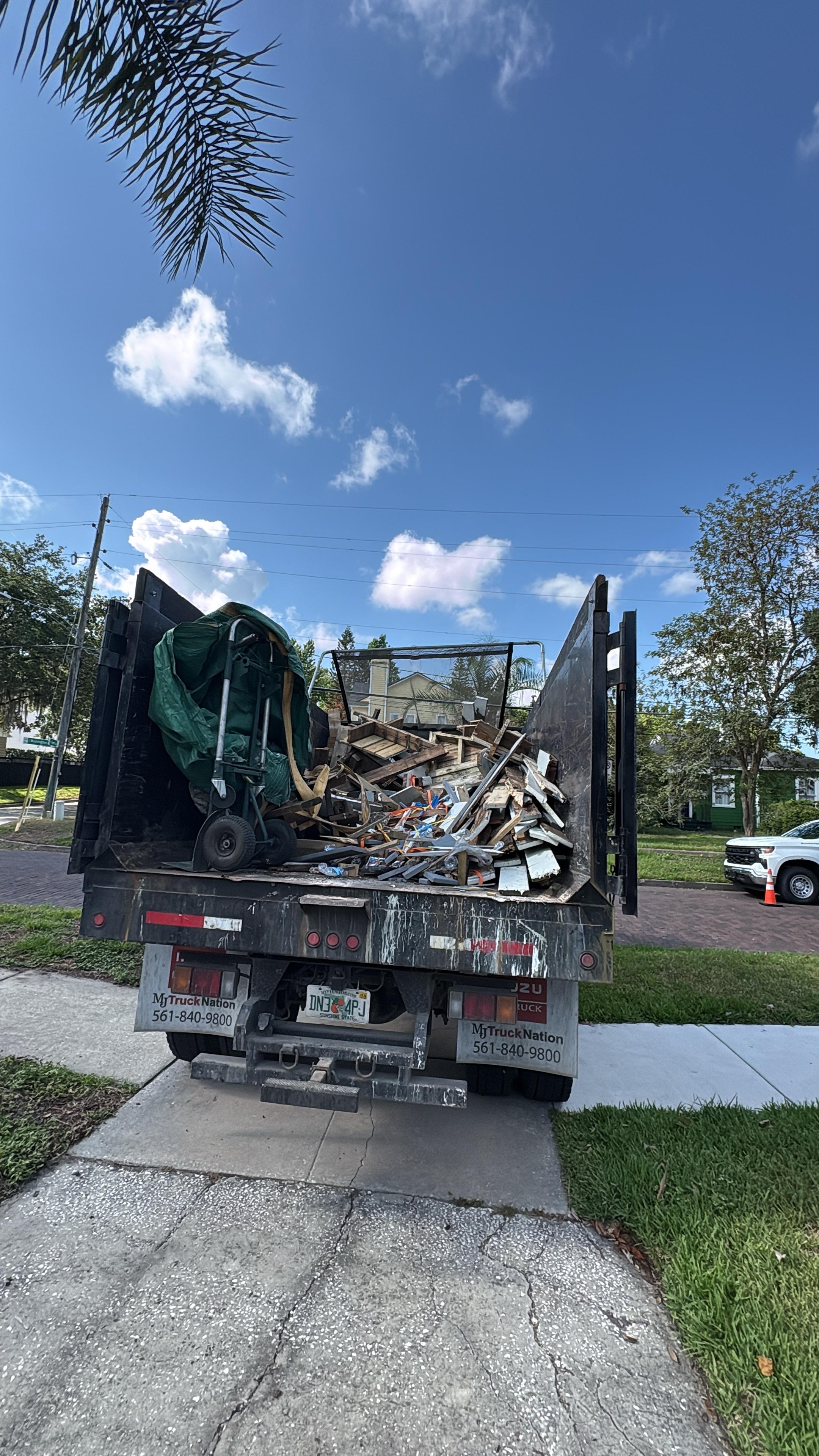 Rear view of Junk Removal Rangers truck fully loaded with deck demolition debris